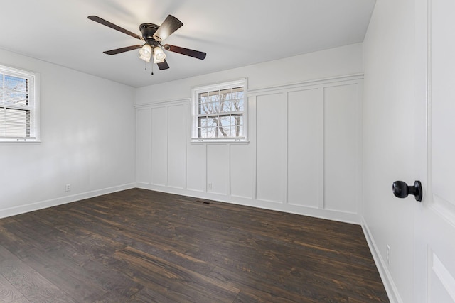 empty room with dark wood-type flooring and ceiling fan