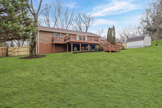 rear view of property with a shed, a yard, and a deck