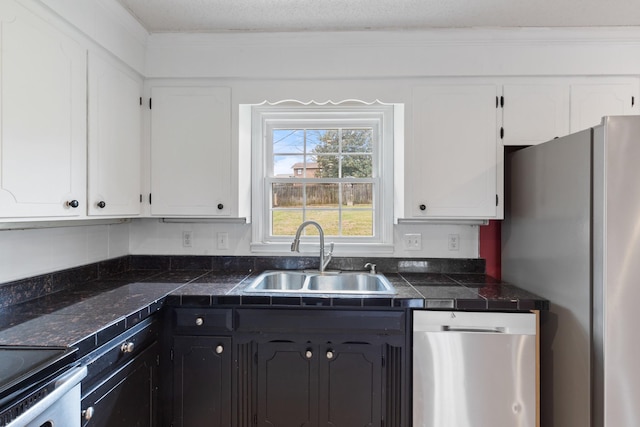 kitchen with sink, a textured ceiling, stainless steel appliances, and white cabinets