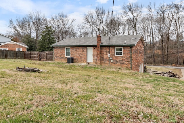 back of house featuring a lawn and central air condition unit