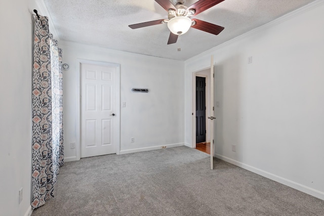 carpeted spare room featuring ceiling fan, crown molding, and a textured ceiling