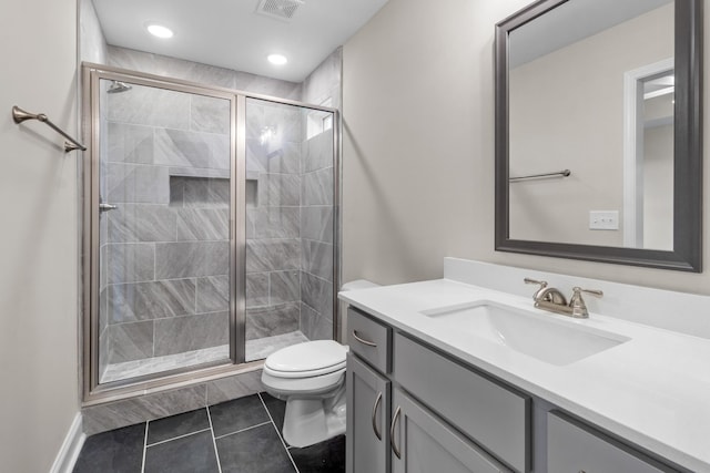 bathroom featuring vanity, tile patterned flooring, a shower with door, and toilet