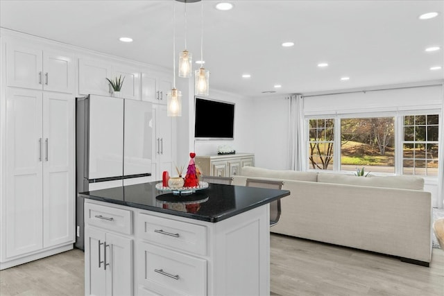 kitchen featuring a center island, white cabinets, and light wood-type flooring