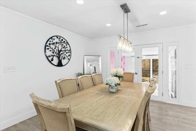 dining area featuring crown molding and light hardwood / wood-style flooring