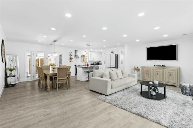 living room featuring ornamental molding and light hardwood / wood-style floors