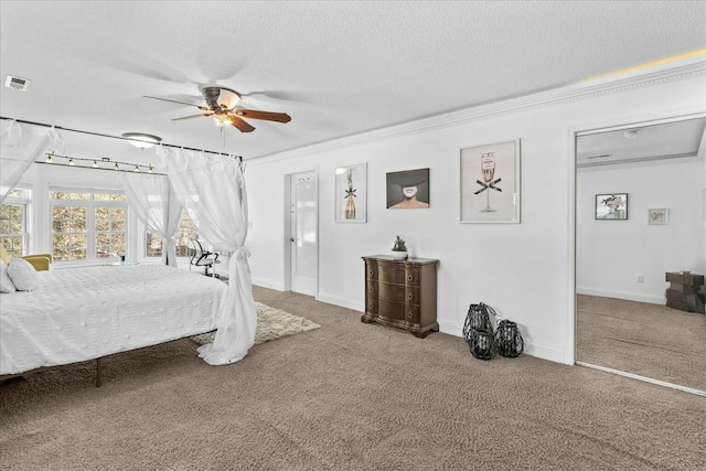 carpeted bedroom with ceiling fan, crown molding, and a textured ceiling