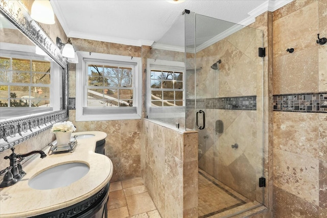 bathroom with tile walls, vanity, a shower with shower door, and ornamental molding