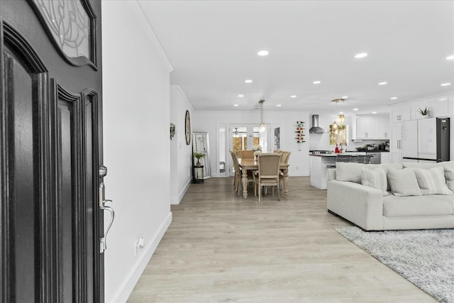 living room with light hardwood / wood-style flooring and ornamental molding