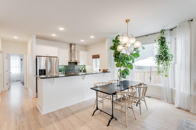 dining room with sink, light hardwood / wood-style flooring, and a chandelier