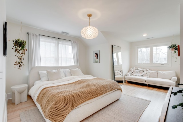 bedroom with vaulted ceiling and light wood-type flooring