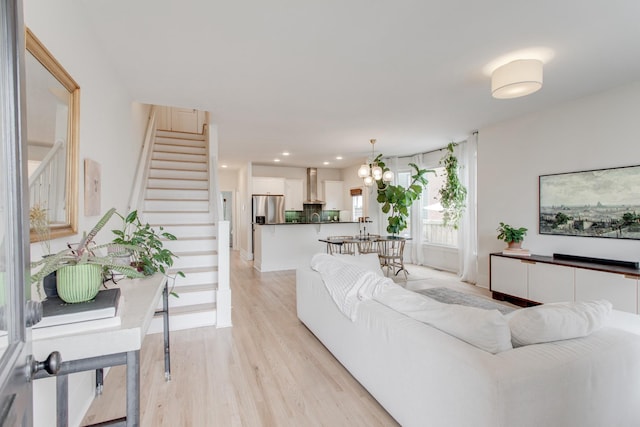 living room with an inviting chandelier and light hardwood / wood-style flooring