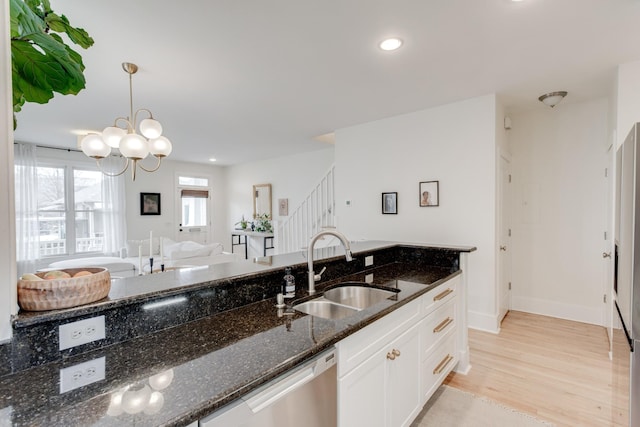 kitchen with sink, pendant lighting, dark stone counters, light hardwood / wood-style floors, and white cabinets