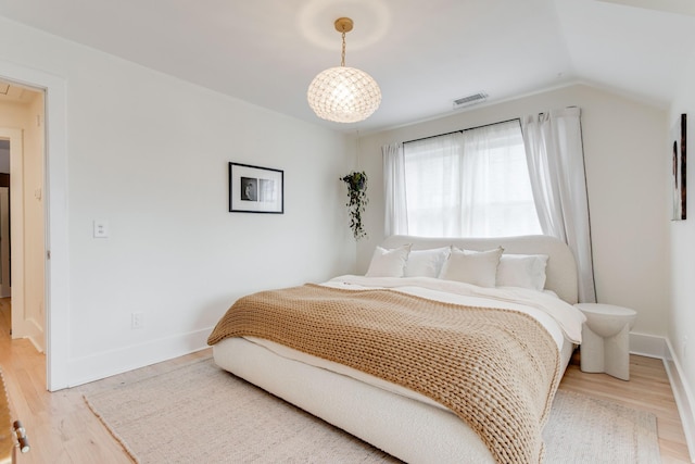 bedroom with hardwood / wood-style floors and vaulted ceiling