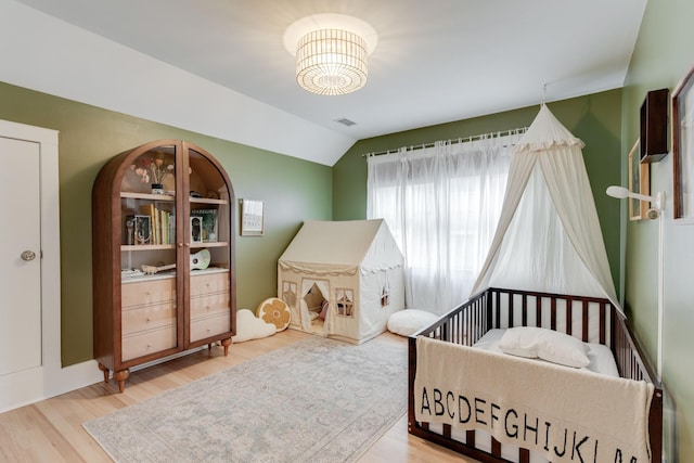 bedroom with vaulted ceiling and hardwood / wood-style floors