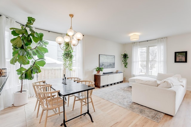 dining room with light hardwood / wood-style flooring, a wealth of natural light, and a chandelier