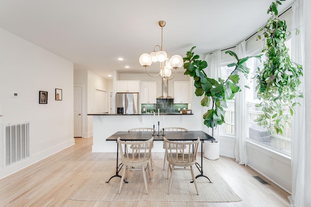 dining area featuring an inviting chandelier and light hardwood / wood-style flooring