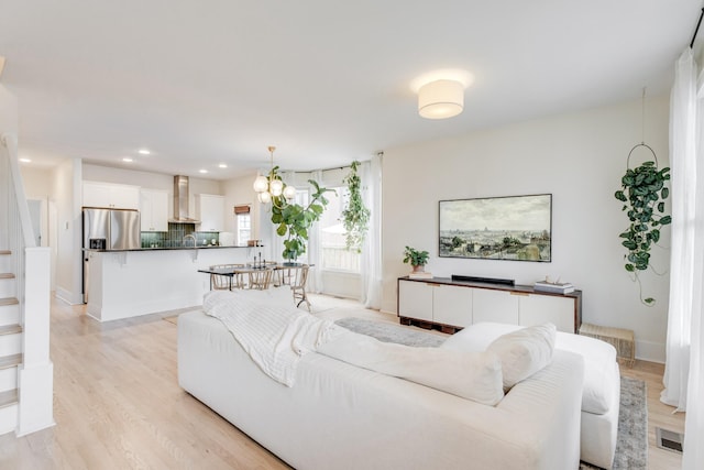 living room featuring an inviting chandelier and light hardwood / wood-style flooring