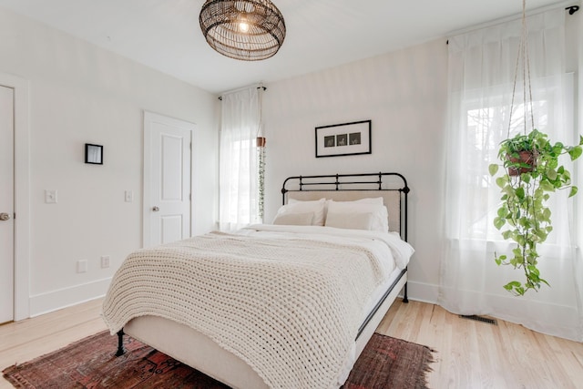 bedroom featuring multiple windows and light hardwood / wood-style flooring