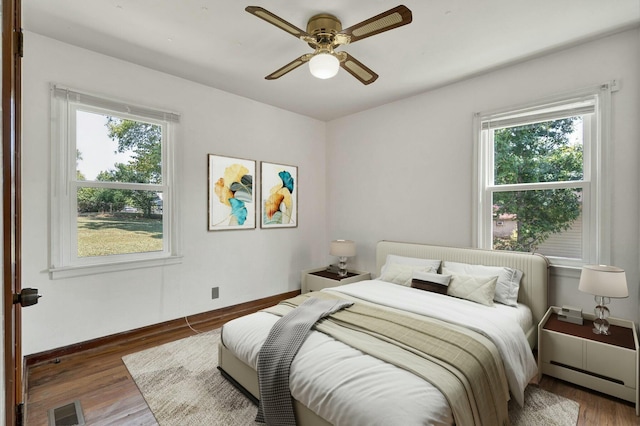 bedroom with ceiling fan and dark hardwood / wood-style flooring