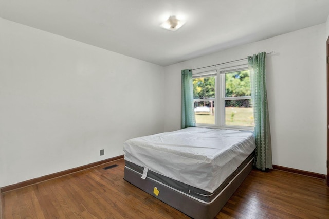 bedroom with dark hardwood / wood-style floors