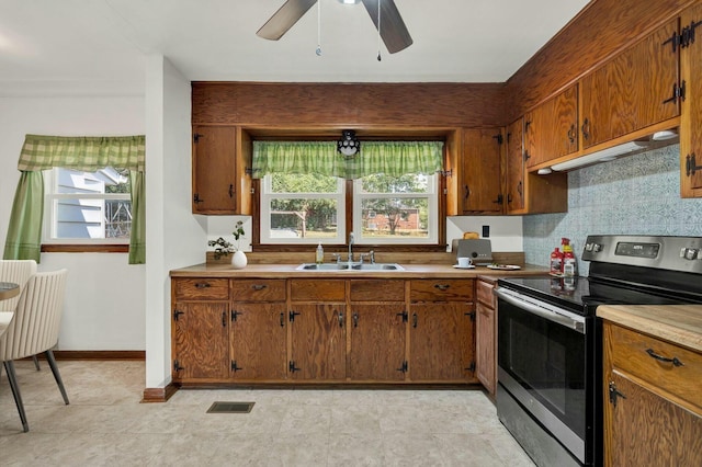 kitchen featuring sink, stainless steel electric range, ceiling fan, and backsplash