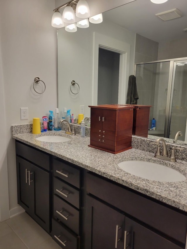 bathroom with an enclosed shower, vanity, and tile patterned flooring