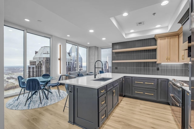 kitchen with a kitchen bar, light hardwood / wood-style floors, sink, and a wealth of natural light