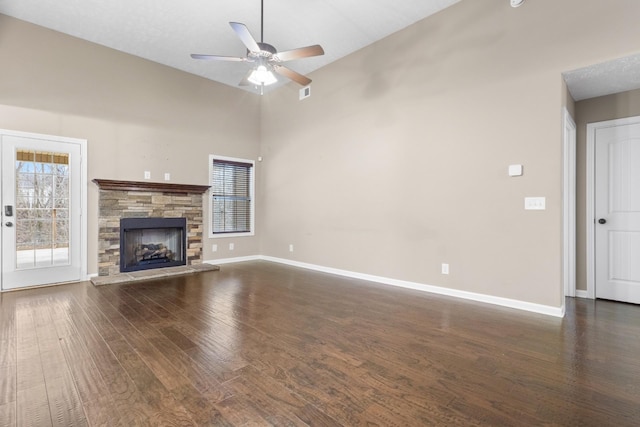 unfurnished living room featuring ceiling fan, a stone fireplace, high vaulted ceiling, and dark hardwood / wood-style flooring