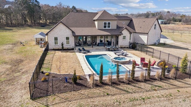 view of swimming pool featuring an in ground hot tub, a patio, and a lawn