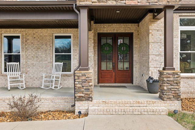 view of exterior entry featuring a porch and french doors