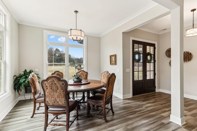 dining area with an inviting chandelier, french doors, dark hardwood / wood-style floors, and ornamental molding