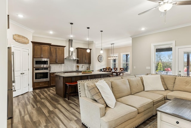 living room with ceiling fan, crown molding, dark hardwood / wood-style flooring, and sink