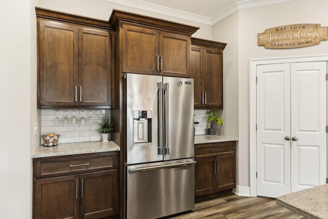 kitchen featuring dark hardwood / wood-style flooring, high end refrigerator, light stone counters, and crown molding