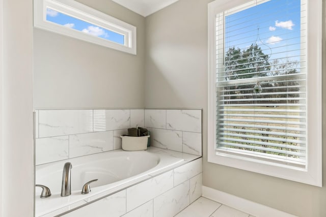 bathroom with tiled tub and tile patterned floors