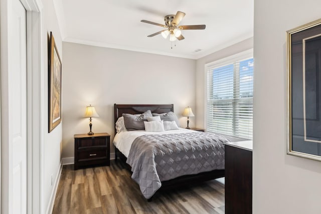 bedroom with ceiling fan, crown molding, and dark hardwood / wood-style flooring