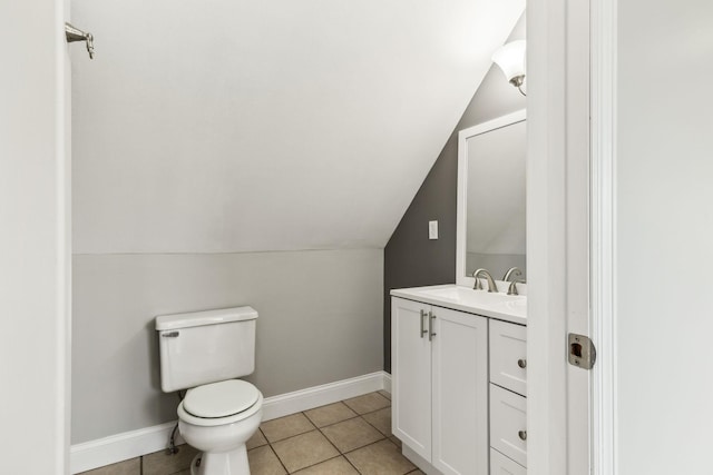 bathroom with vanity, toilet, tile patterned floors, and lofted ceiling