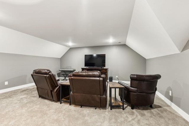 cinema room featuring light carpet and vaulted ceiling