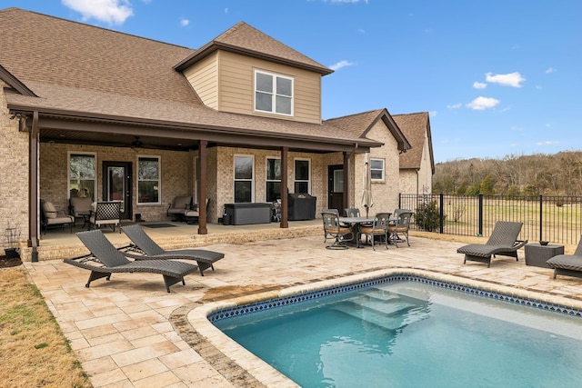 rear view of property featuring a patio area, a fenced in pool, and ceiling fan