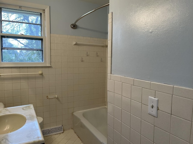 bathroom with tile patterned flooring, vanity, tile walls, and bathing tub / shower combination