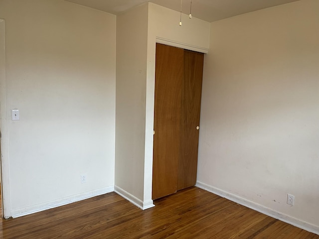 unfurnished bedroom featuring dark hardwood / wood-style floors and a closet