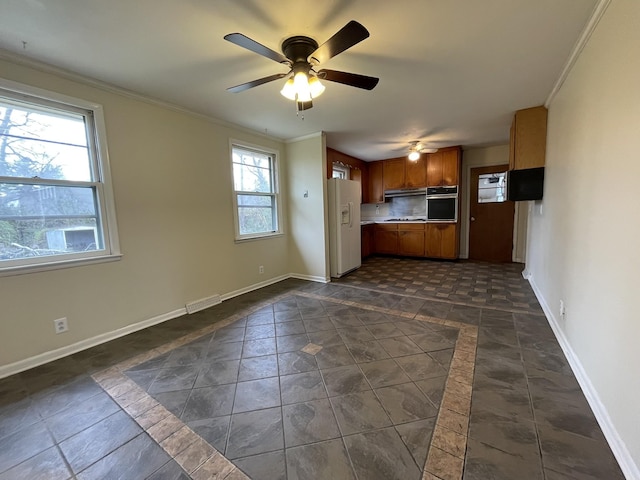 kitchen featuring ceiling fan, ornamental molding, oven, and white fridge with ice dispenser