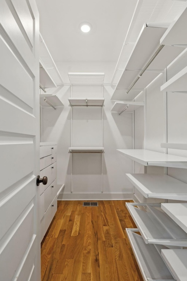 spacious closet with dark hardwood / wood-style flooring