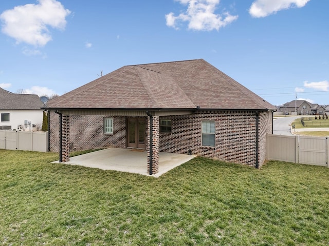 back of house featuring a lawn and a patio area