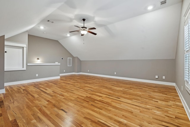 additional living space with ceiling fan, lofted ceiling, and light wood-type flooring