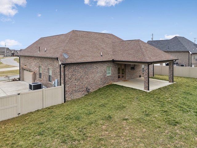 back of house featuring a garage, a yard, central AC, and a patio area