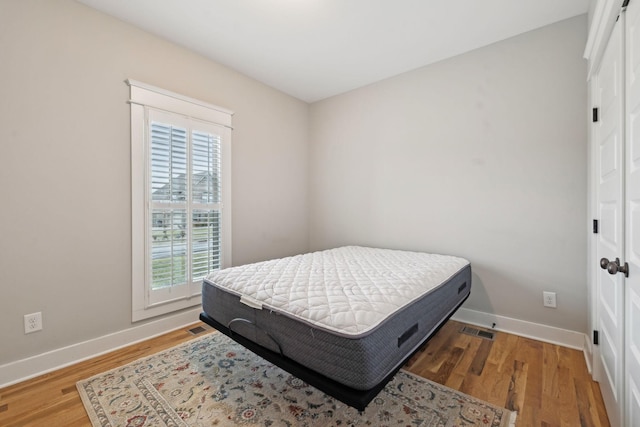 bedroom with dark hardwood / wood-style flooring and a closet