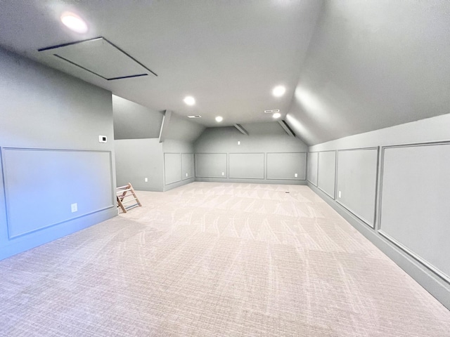 bonus room with vaulted ceiling and light colored carpet