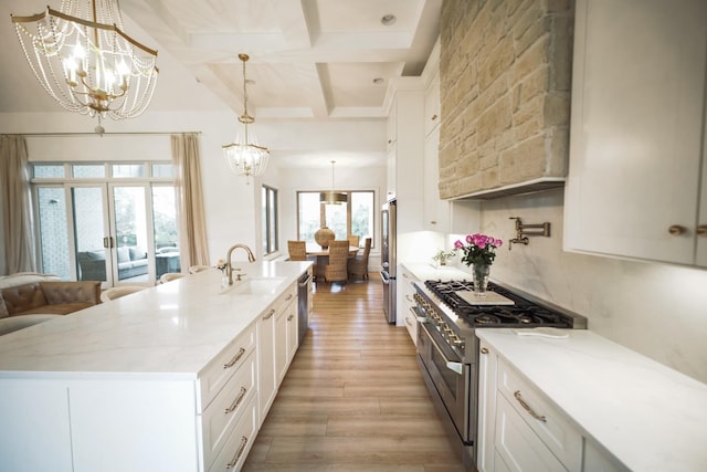 kitchen with an inviting chandelier, high quality appliances, hanging light fixtures, and white cabinets