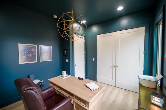 home office featuring light wood-type flooring and a notable chandelier