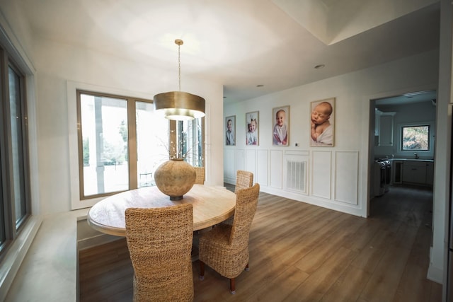 dining room with dark wood-type flooring and a healthy amount of sunlight